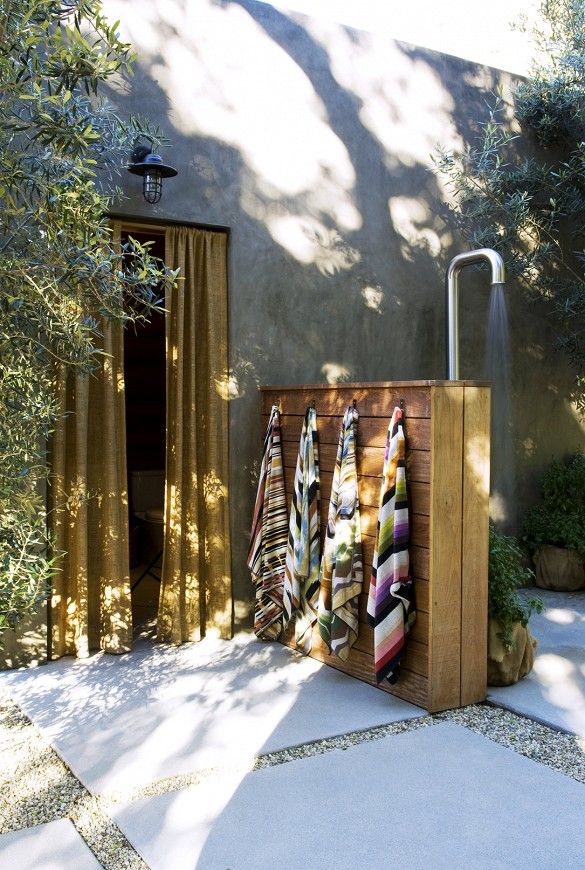 towels are hanging on a wooden rack outside