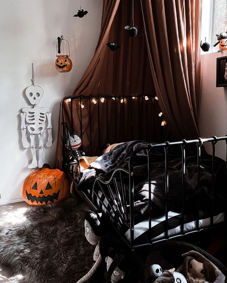 a bedroom decorated for halloween with pumpkins and decorations