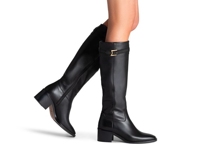 The Maya Rider is the epitome of equestrian inspired elegance, designed with a sleek and modern silhouette that effortlessly commands attention. This fashion-forward riding boot features an inside zipper for easy wear, while the ornamental strap adorned with a gold "M" adds a chic touch. Luxury Knee-high Boots With Leather Lining For Work, Luxury Leather-lined Knee-high Boots For Work, Luxury Calf Leather Knee-high Boots For Business, Luxury Knee-high Heeled Boots For Business, Luxury Calf Leather Knee-high Boots For Formal Wear, Luxury Calf Leather Knee-high Boots For Formal Occasions, Elegant Knee-high Riding Boots, Designer Knee-high Boots For Business In Fall, Luxury Leather Knee-high Boots For Formal Occasions