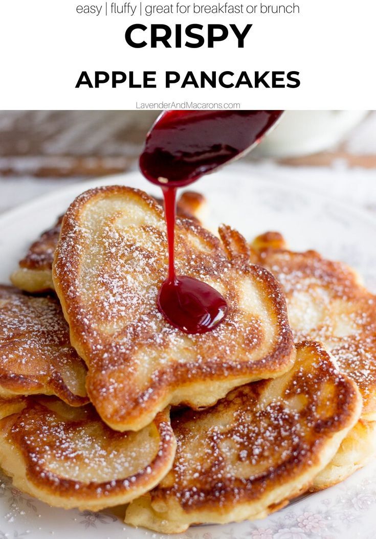 a stack of pancakes covered in powdered sugar with syrup being drizzled on top