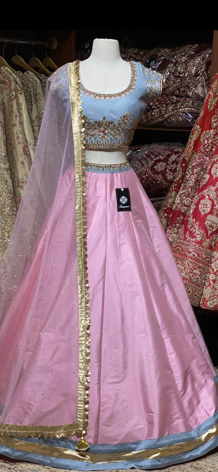 Blush pink lehenga with contrasting steel blue zardozi, cut dana, thread embroidered and stone work blouse and net dupatta. Fabric: Raw Silk This outfit can be customized in multiple colors and specific to client measurements. 90 days of production time is required and are for bulk orders only! Orders are processed in store only! Final fittings/alterations not included. Minimum Order Quantity- 4 pieces Pink Tissue Silk Sharara With Mirror Work, Pink Sharara With Mirror Work In Tissue Silk, Pink Anarkali Choli With Cutdana, Pink Kundan Anarkali Set With Cutdana, Designer Pink Lehenga With Cutdana Detail, Designer Pink Lehenga With Cutdana, Pink Tissue Silk Choli With Mirror Work, Designer Pink Lehenga With Sheer Dupatta, Festive Pink Lehenga With Cutdana Detail