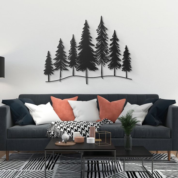 a living room with black and white furniture and trees on the wall behind it,