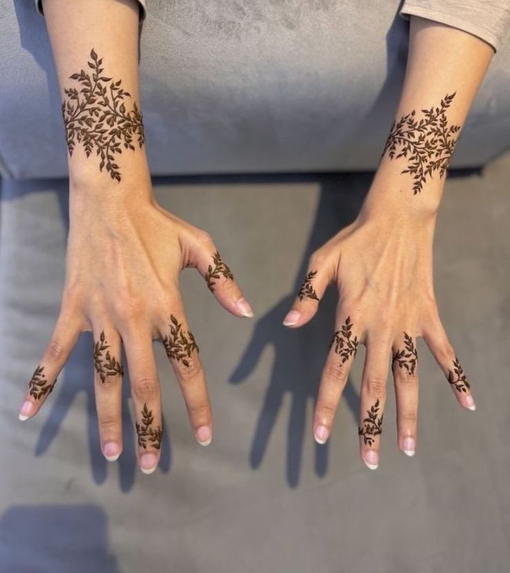 two hands with henna tattoos on them