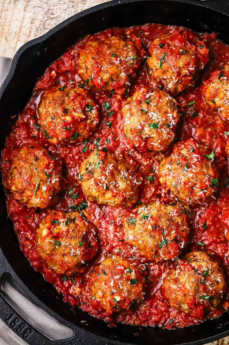 meatballs covered in marinara sauce in a cast iron skillet