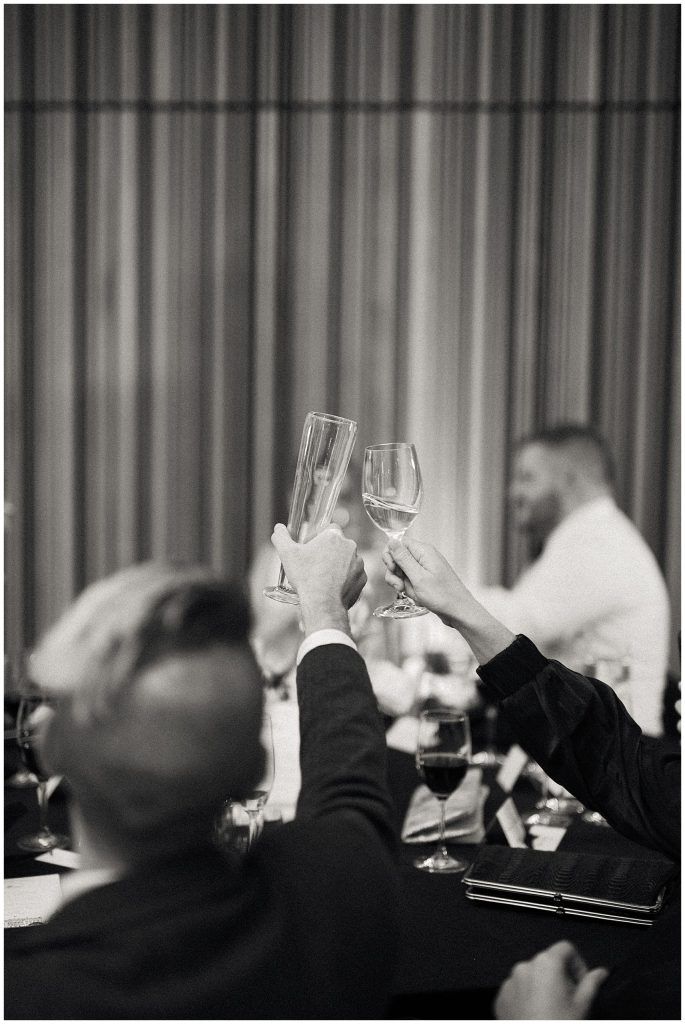 black and white photograph of people toasting with wine glasses