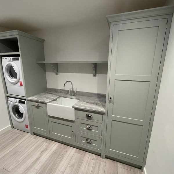 a laundry room with washer, dryer and cabinets in it's corner