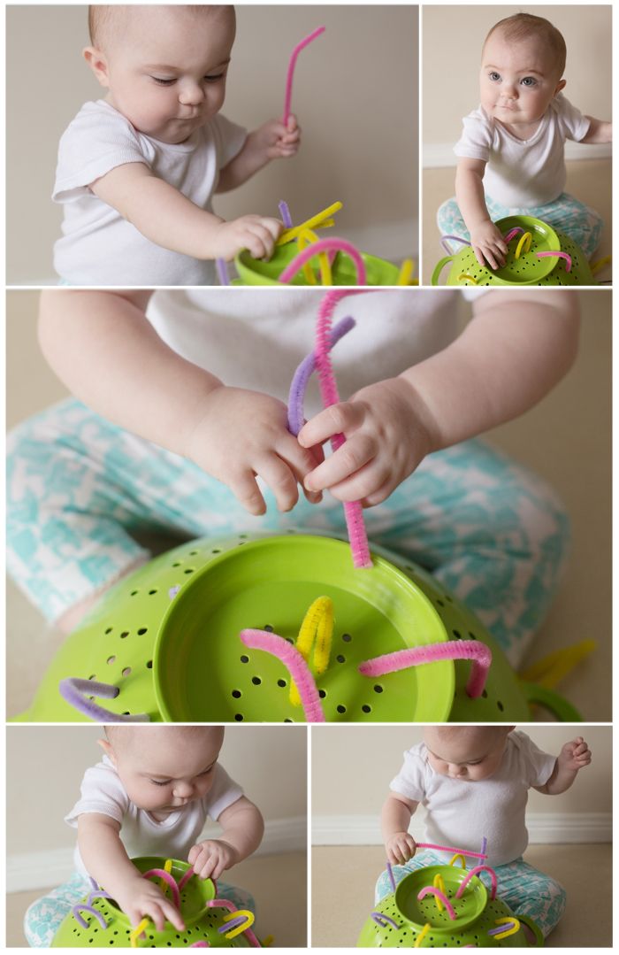 the baby is playing with his toys on the floor, and then trying to put them in