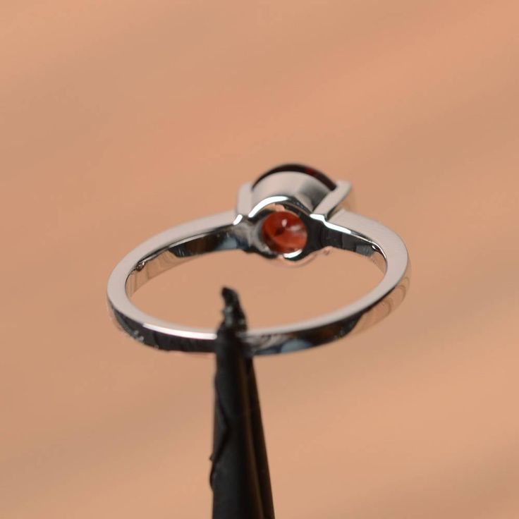 It is a natural garnet ring. The main stone is 7 mm*7 mm round cut.weight about 1.68 carats. The basic metal is sterling silver and plated with rhodium. To change the metal to a solid gold (white/rose) or platinum is also available, please ask for a quotation if you want. You can also go to my shop Home for more elegant rings: https://www.etsy.com/shop/godjewelry?ref=hdr_shop_menu Garnet is the January birthstone More garnet rings: https://www.etsy.com/shop/godjewelry?section_id=20709242 Customi Garnet Birthstone Ring For Anniversary, Anniversary Garnet Birthstone Ring, Silver Garnet Solitaire Ring, Silver Garnet Ring With Prong Setting, Garnet Solitaire Jewelry For Promise Ring, Round Garnet Solitaire Ring, Garnet Solitaire Rings, Ruby Promise Ring With Tension Setting, Silver Garnet Birthstone Ring For Promise