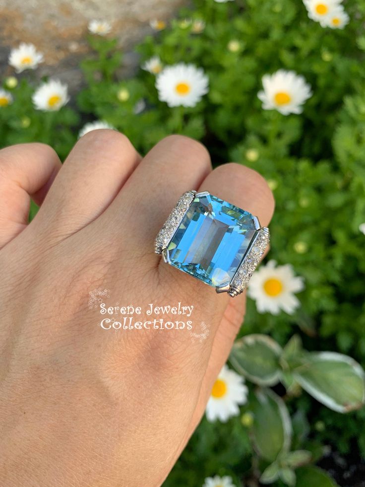 Thank you for coming in! Impressive blue aquamarine Platinum vintage diamond ring with a fancy diamond setting. Ring Size: 6 Total Weight: 14.03 grams Precious Metal: Platinum Precious stones: -Aquamarine Center Stone: 18.5 carats, 18.7mmx15.5mm -White Round Diamonds: 0.6 carats, QTY: 20 Luxury Topaz Ring With Diamond Accents, Formal Light Blue Diamond Ring, Aquamarine Brilliant Cut Diamond Ring For Formal Occasions, Luxury White Gold Ring With Aquamarine, Formal Aquamarine Diamond Ring With Brilliant Cut, Luxury White Gold Aquamarine Ring, Luxury Topaz Ring With Accent Stones, Formal Light Blue Aquamarine Diamond Ring, Luxury Aquamarine Diamond Ring With Prong Setting