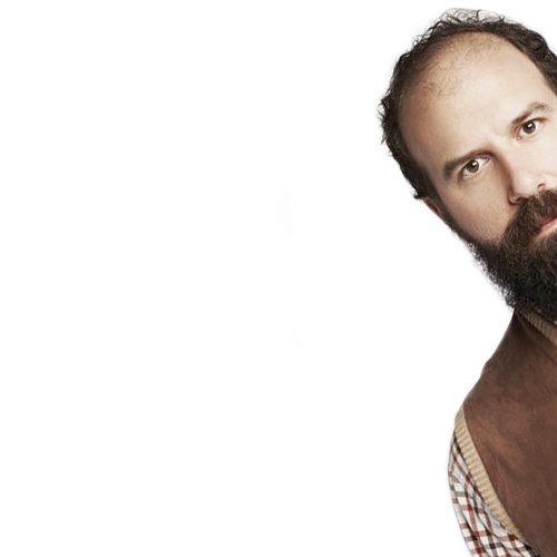 a man with a beard wearing a brown vest