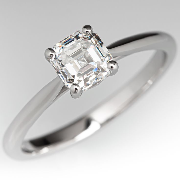 an engagement ring with a square cut diamond in the center, on a white background