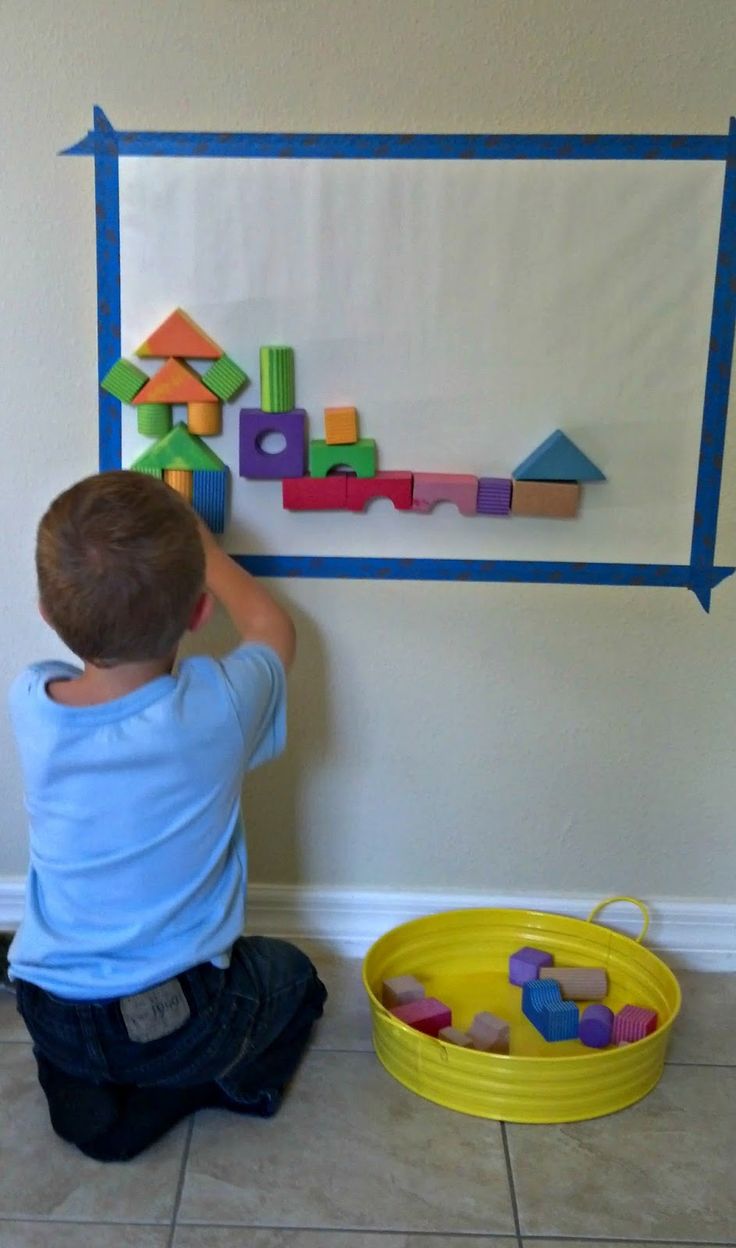 a young boy is playing with toys on the wall