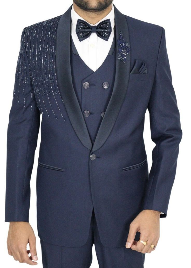 Elegance personified, this navy blue wedding tuxedo suit redefines formal attire. Its exquisite hand-embroidery, brimming with intricate details, transforms it into a masterpiece fit for any grand occasion. The shawl lapel, a hallmark of sophistication, elevates this suit to a league of its own. Every stitch, every thread, bears witness to the meticulous craftsmanship that went into creating this remarkable ensemble. From the precise tailoring to the hand-embroidered embellishments, it's a testament to timeless artistry. Whether you're stepping into the role of the groom, an honored guest, or simply a style connoisseur, this tuxedo suit is your ticket to leaving an indelible mark. It embodies a timeless quality that not only impresses but lingers in memory, ensuring it holds a treasured pl Royal Fitted Tuxedo For Formal Occasions, Royal Fitted Tuxedo For Formal Events, Blue Tuxedo Three-piece Suit For Party, Tailored Suits For Wedding And Gala, Royal Blue Tuxedo Suit For Party, Blue Tuxedo Blazer For Ceremonies, Blue Tuxedo Style Blazer For Ceremonies, Blue Tuxedo Style Three-piece Suit For Wedding, Formal Blue Embellished Sets