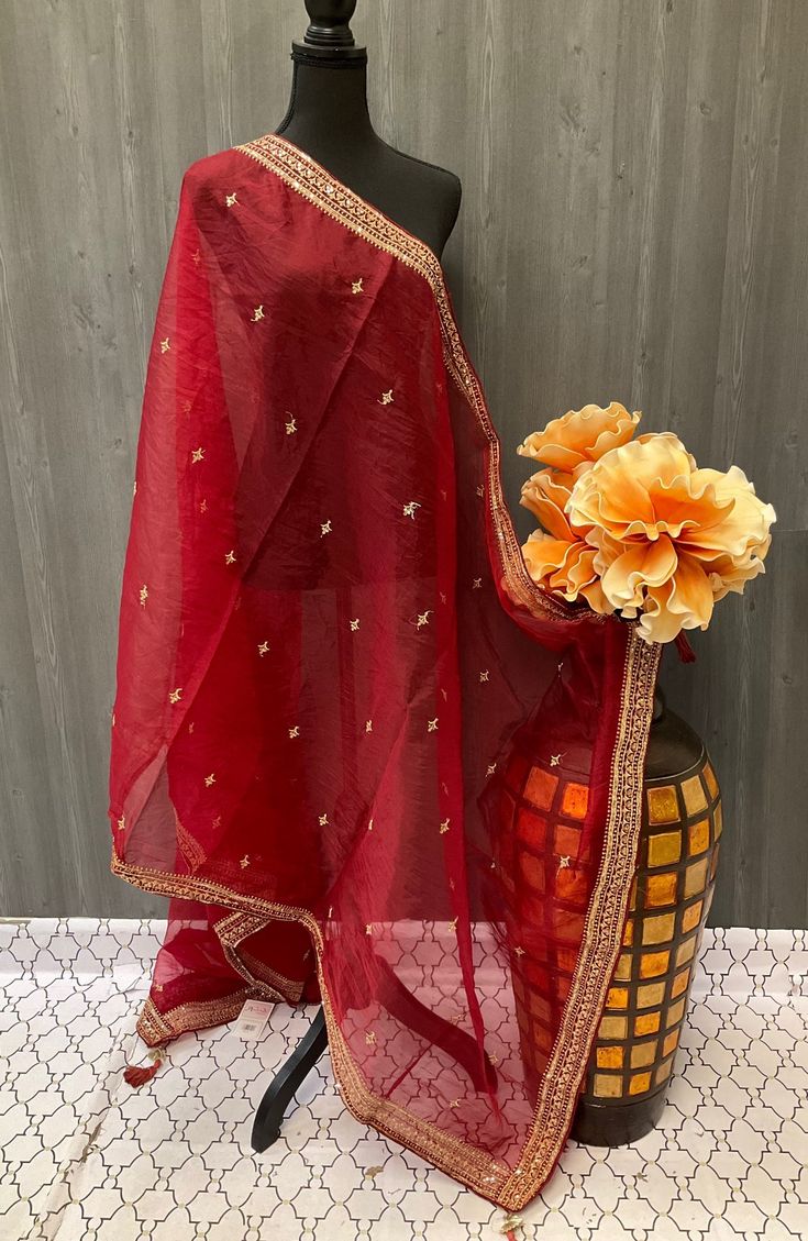 Add a touch of elegance and charm to your outfit with our stunning Dupatta collection. Made from high-quality fabrics such as chiffon, georgette, and silk, our Duppattas are lightweight and perfect for all seasons. The intricate embroidery and embellishments on the Duppattas add a hint of glamour to your ensemble, making you stand out at any occasion. Whether you're looking for a traditional Duppatta to pair with your ethnic attire or a modern design to elevate your everyday look, we have a wide Red Churidar With Sheer Dupatta In Chinon, Red Organza Blouse Piece With Sheer Dupatta, Elegant Georgette Saree With Sheer Dupatta, Festive Semi-stitched Tissue Silk Dupatta, Transitional Organza Salwar Kameez With Cutdana Details, Red Tissue Silk Dupatta With Dori Work, Unstitched Red Organza Blouse Piece, Elegant Silk Churidar With Zari Work, Elegant Churidar With Chinon And Traditional Drape