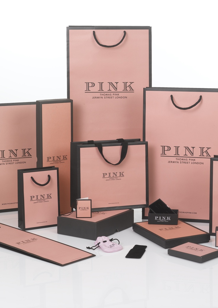 pink paper shopping bags and other items on a table