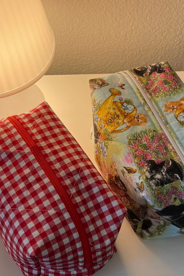 two bags sitting on top of a table next to a lampshade and lamp shade