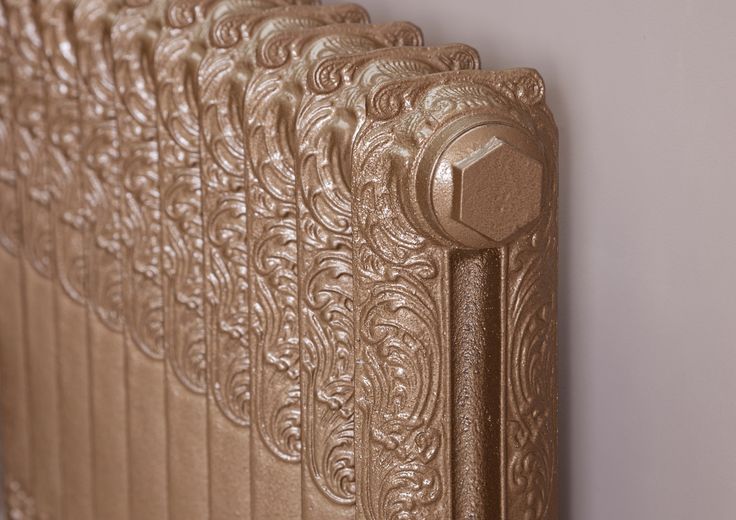 an ornate gold radiator in the corner of a room