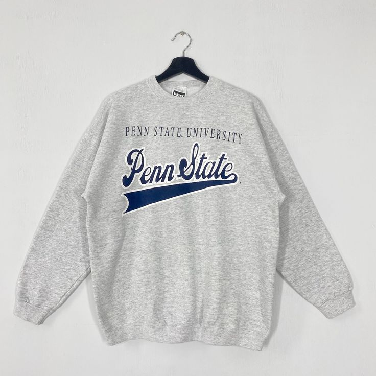 Vintage Pennsylvania State University Sweatshirt Pennsylvania Crewneck Pennsylvania Sweater Penn State Nittany Lions Print Logo Grey Large 𝐁𝐫𝐚𝐧𝐝 :- Pennsylvania State University  𝐒𝐢𝐳𝐞 𝐓𝐚𝐠 :- Large Manual Measurement :- 𝐖𝐈𝐃𝐓𝐇 (armpit to armpit) :- 23 inches / 58cm 𝐋𝐄𝐍𝐆𝐓𝐇 (shoulder to end of garment) :- 27 inches / 69cm 𝐂𝐨𝐧𝐝𝐢𝐭𝐢𝐨𝐧 :- Good Condition 8/10.                      - No Hole, No Stain. - Colors Might Be Different Due To Lighting. - All items are VINTAGE whi Vintage Gray Tops For College, Collegiate Winter Tops With Text Print, Vintage Long Sleeve Tops With Lettering, Vintage Gray Tops With Ribbed Cuffs, Varsity Style Winter Top With Lettering, Varsity Style Top With Lettering, Winter College Tops With Lettering, Lettering Tops For College In Winter, Pennsylvania State University