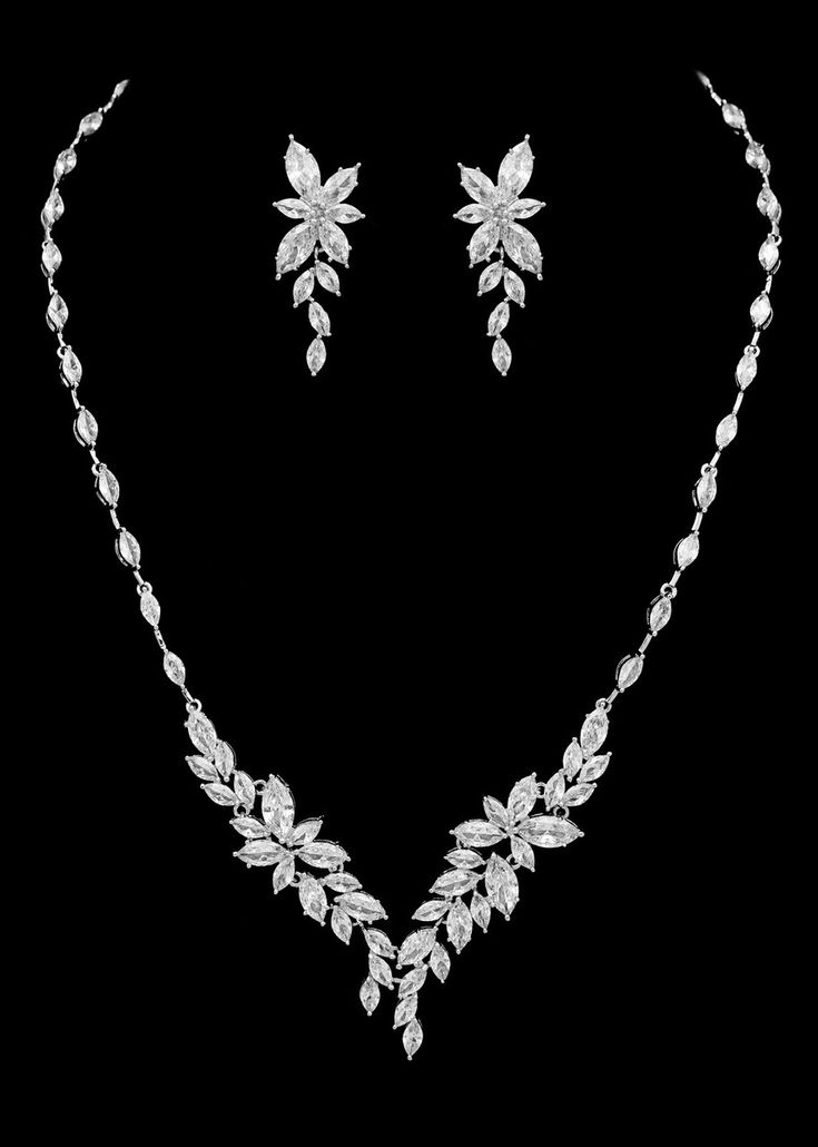 a necklace and earring set with leaves on the front, in white gold plated