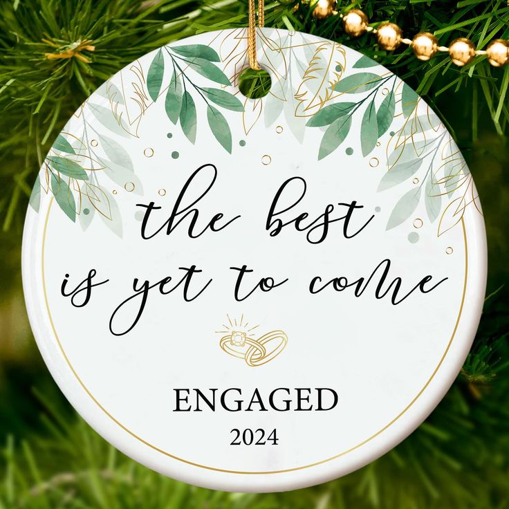 the best is yet to come engaged ornament hanging on a christmas tree branch