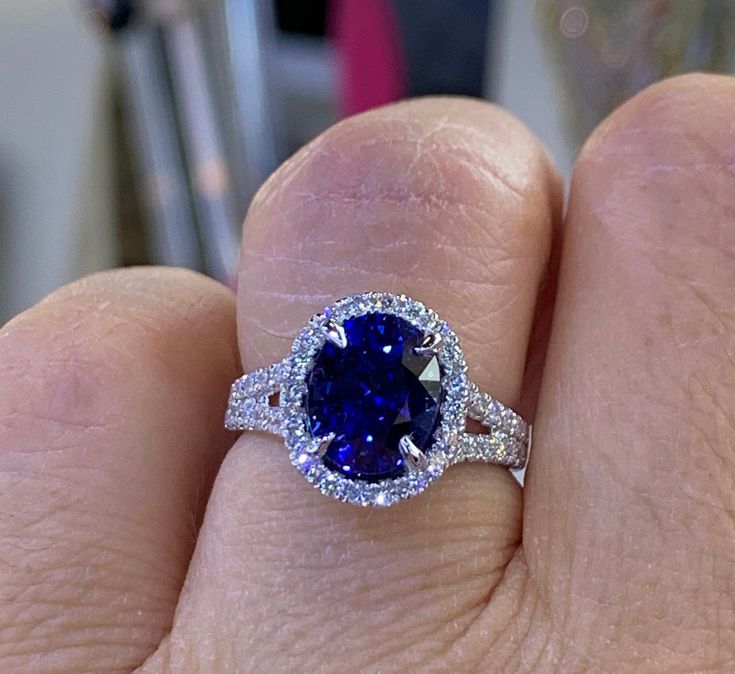 Classy Blue Sapphire And Diamond Ring set in 18K White Gold. The cut and color of this stone is stunning; it has a lot of sparkles. Excellent craftsmanship with nice design details on the side of the ring. The split shank design is very pretty. This royal blue sapphire is lab created. It's a hard stone so can be worn daily won't scratch easily. All diamonds are very sparkling. Nice and smooth setting. Very comfortable band, not bulky. The halo measures 13.1 x 11.5mm. Oval Shape Lab Created Blue Dazzling Sapphire Ring With Diamond, Dazzling Sapphire Rings Gia Certified, Dazzling Gia Certified Sapphire Diamond Ring, Exquisite Sapphire Ring With Diamond Accent Stones, Dazzling Brilliant Cut Sapphire Ring, Oval Sapphire Gemstones In Halo Setting, Dazzling Sapphire Diamond Ring, Dazzling 14k White Gold Diamond Ring With Gemstone, Dazzling Sapphire Ring With Accent Stones