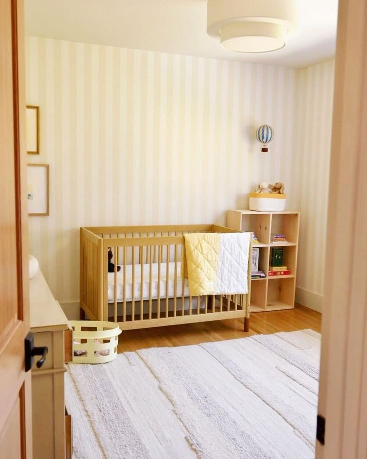 a baby's room with a crib and bookshelf in the corner