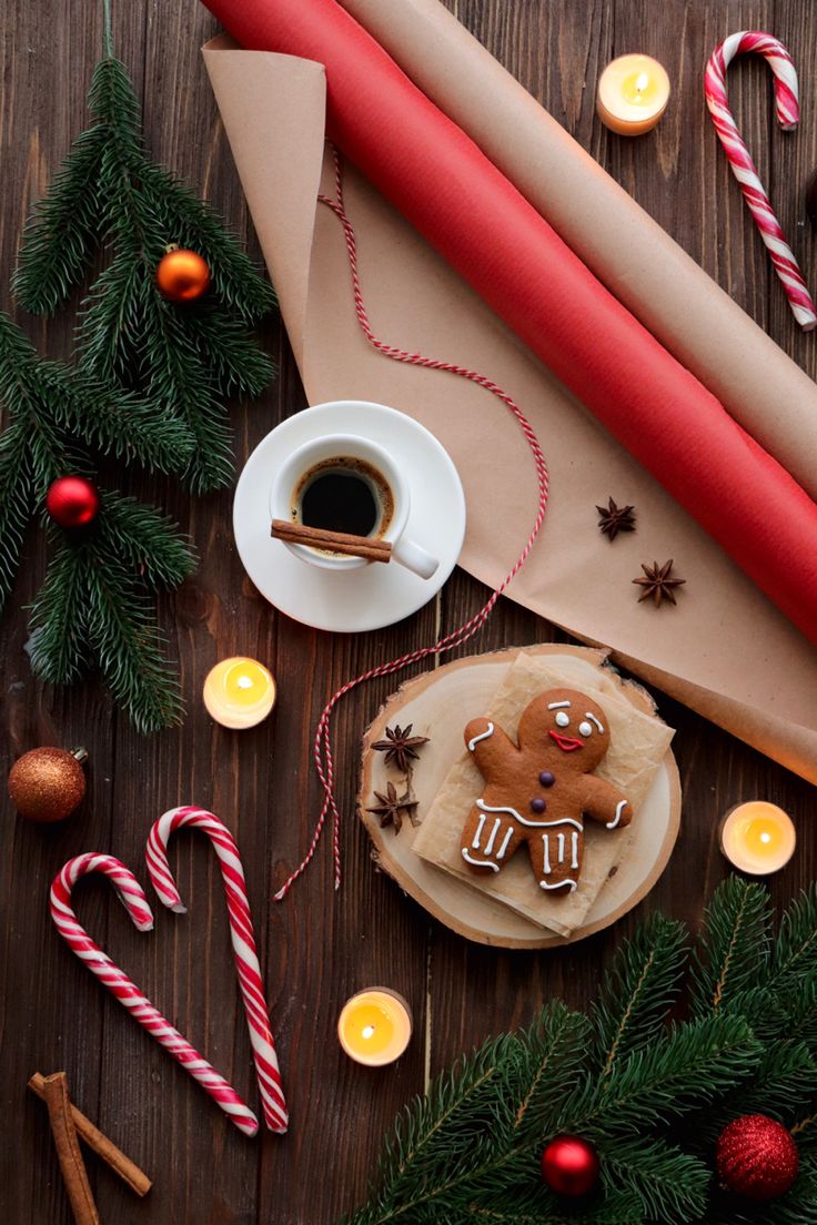 a table topped with lots of christmas decorations next to candles and candy canes on top of a wooden table