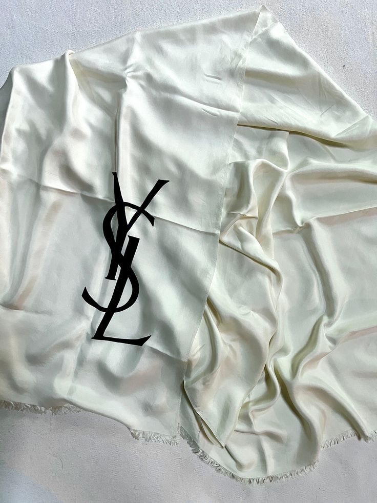 Vintage 1970s Yves Saint Laurent YSL white 100% silk foulard scarf / stole / shawl  * extremely rare, very large * white silk with large black YSL logo (color is white even though some photos it appears more ivory) * fringed edges label: marked YSL and has Made in France label (see photo) material: 100% silk measurements: approx 35.5" wide and approx. 70" long condition: excellent vintage. no flaws found all items are final sale, please review information before purchasing **I use recycled shipping envelopes / boxes. Please let me know if you do not want that** Luxury White Silk Scarves, White Silk Scarf Shawl, Designer White Silk Scarves, White Silk Shawl Scarf, White Silk Shawl Scarf For Summer, White Silk Summer Scarf, Shipping Envelopes, Ysl Logo, White Silk