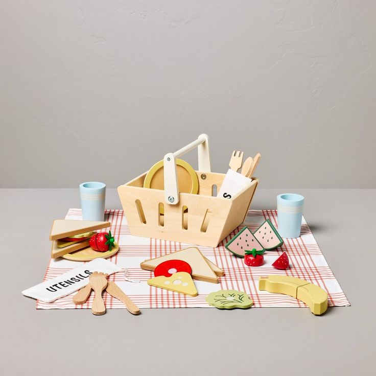 a wooden toy picnic set with utensils and cheese