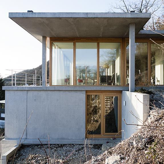 a concrete house with large windows on the side