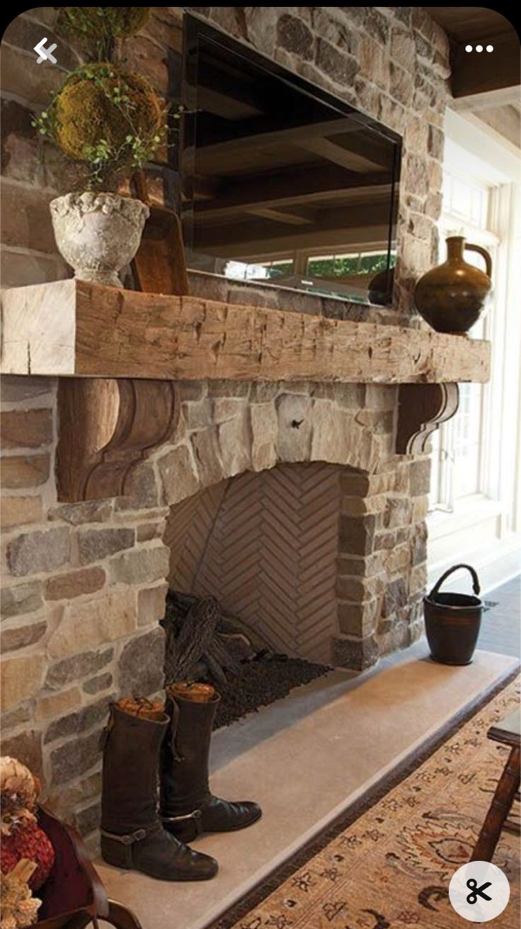 there is a fireplace in the living room with boots and a teddy bear next to it