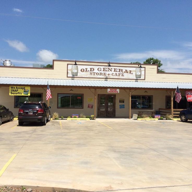 an old general store with cars parked in front