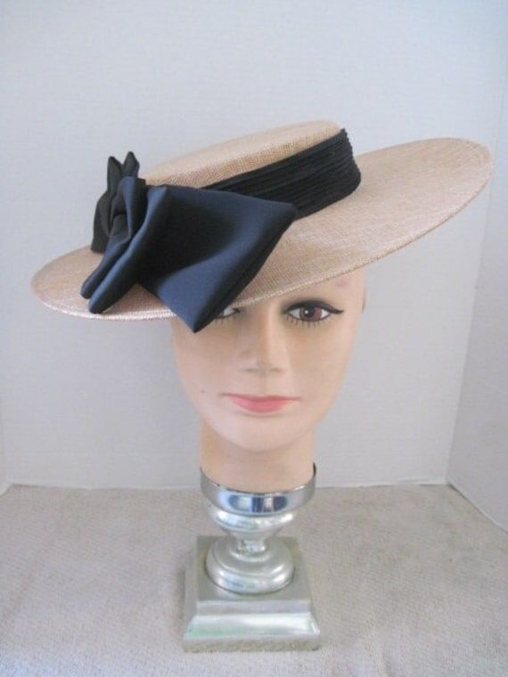 *  This classic design features a tan Sinamay hat form with a jumbo black satin bow.  It is slightly oval and the bow can be worn on either the right side or left side of the head. *  The black elastic band secures the design and it is light weight and comfortable to wear. *  Designed for any Easter Event, Mother's Day Celebration, Derby occasion, Wedding Event, Fashion Show, Birthday Celebration, Garden or Tea Party, Baby or Wedding Shower, Ladies Gathering or just for fun. Formal Wide Brim Hat With Ribbon, Formal Hat With Ribbon And Curved Brim, Chic Boater Hat With Bow And Curved Brim, Chic Boater Hat With Curved Brim And Bow, Chic Brimmed Boater Hat With Bow, Kentucky Derby Evening Hat With Satin Bow, Formal Hats With Bow And Adjustable Fit, Evening Hat With Ribbon And Curved Brim, Formal Hat With Adjustable Bow