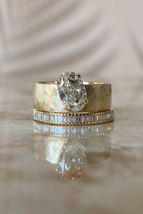 two gold wedding bands with a diamond in the middle