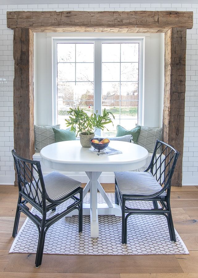 a dining room table with two chairs and a potted plant on top of it