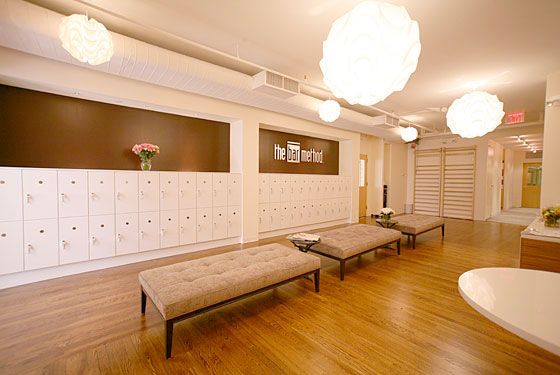 an empty room with several lockers and benches in the center, along with flowers