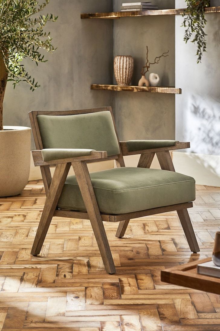 a chair sitting on top of a wooden floor next to a potted plant