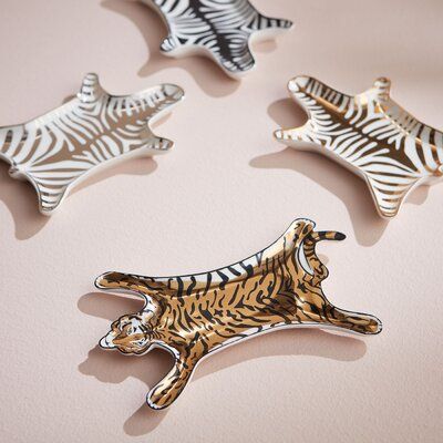 four different animal brooches sitting on top of a pink surface with white and black stripes