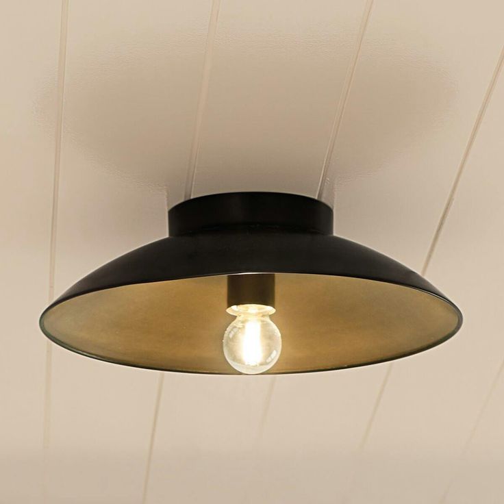 a light that is hanging from the ceiling in a room with white walls and wood paneling