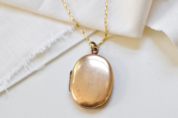 The perfect gift for a bride, mother, graduate, or birthday. Find affordable antique and vintage inspired jewelry here. Personalize by adding sentimental pictures, a tiny note, or a lock of hair. Select the customization option if you would like me to personalize before shipment. This oval antique locket features a sleek geometric oval shape with minimal detailing.  | PRODUCT DETAILS | * Style: Victorian * Circa: 1880-1900's * Measurements: approx. 1 1/2" total length * Locket Material: Gold Fil Vintage Antique Gold Jewelry For Anniversary, Elegant Antique Gold Locket Necklace For Formal Occasions, Elegant Antique Gold Locket Necklace For Formal Events, Hallmarked Oval Pendant Locket Necklace For Wedding, Vintage Charm Medallion Necklace For Anniversary, Vintage Pendant Jewelry For Anniversary, Elegant Gold Locket Necklace With Antique Finish, Antique Gold Oval Pendant Necklace For Wedding, Gold Necklaces With Antique Finish For Anniversary