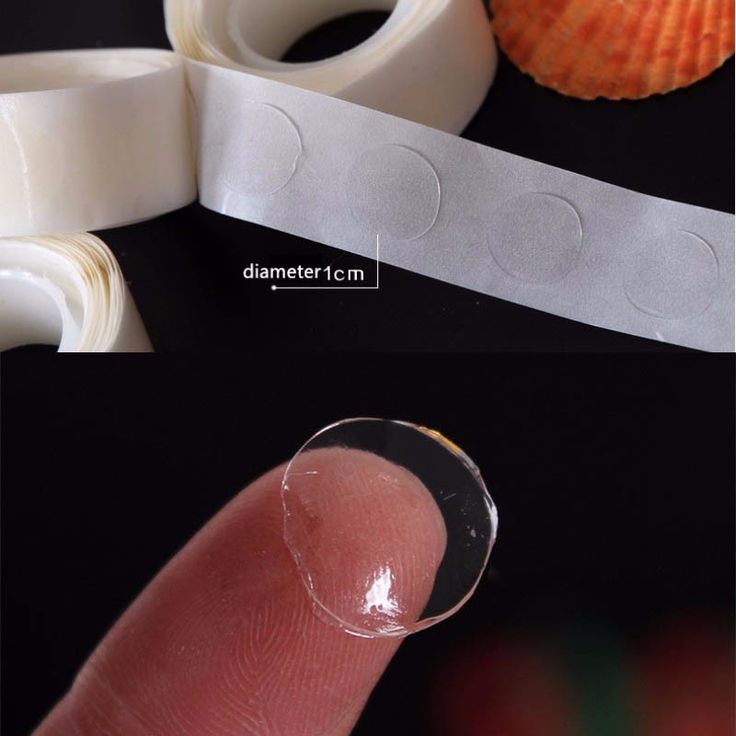 the finger is next to some tape and an orange shell