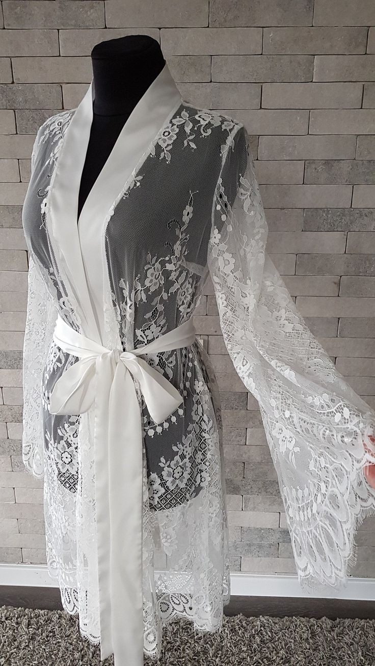 Off-white luxurious wedding robe, to add a perfect touch to your perfect and unique day. Only high quality fabrics and high finishing used for making the robe as neat as it can be. Please find the wedding robes collection here https://www.etsy.com/shop/LidiasBoutiqueDesign?ref=seller-platform-mcnav&section_id=25023222. For wedding dresses, please access https://www.etsy.com/shop/LidiasBoutiqueDesign?ref=seller-platform-mcnav§ion_id=23157290. For wedding tops and boleros, please access https: Feminine Lace Gown With Delicate Details, Delicate Lace Robe For Wedding Night, Lace Wedding Night Robe With Lace Sleeves, Lace Dress With Lace Cuffs For Wedding Night, Elegant Lace Bride's Robe, Elegant Lace Bridal Robe, Feminine Lace Gown With Lace Trim, Fitted Robe With Lace Sleeves For Wedding Night, Feminine Lace Robe For Wedding Night