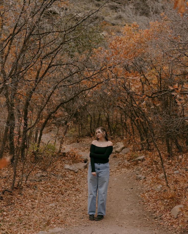 a woman standing on a path in the woods