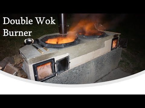 a double wok stove with flames coming out of it