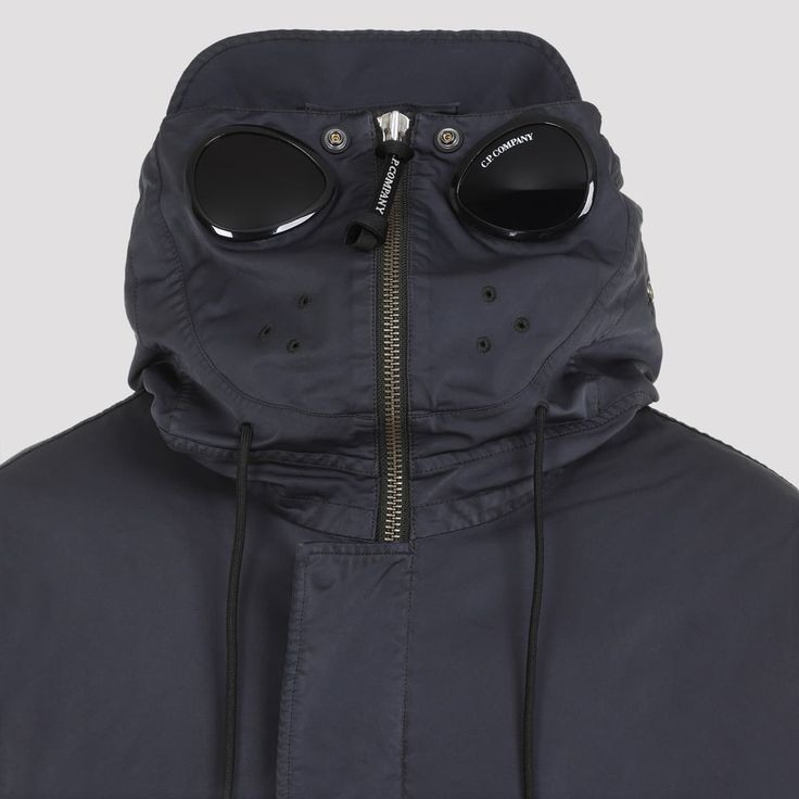 CP Company Black Long Down Jacket. Black tech fabric, attached drawstring hood with signature Goggle insert, long sleeves, concealed front fastening, side pockets, coulisse on waist and on the bottom. Fully lined, logo label, regular fit.Gender: MenMaterial: 66%POLYESTER 34%POLYAMIDEColor: BlackMade in: IMPORTEDProduct ID: MOW227A.110089G_995*Import tax/duty will be calculated at checkout (If applicable) Modern Black Outerwear With Drawstring Hood, Hooded Outerwear With Functional Drawstring For Streetwear, Modern Hooded Windbreaker With Pockets, Modern Streetwear Parka With Pockets, Winter Hooded Parka With Functional Drawstring, Hooded Winter Parka With Functional Drawstring, Urban Hooded Outerwear With Functional Drawstring, Modern Black Parka With Detachable Hood, Hooded Nylon Parka With Functional Drawstring