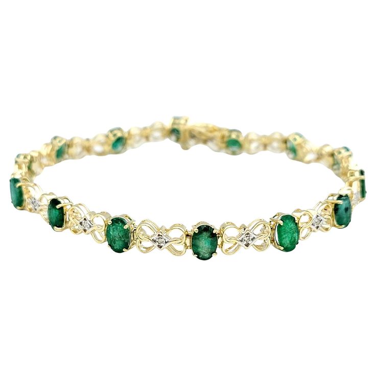 This elegant 14 karat gold tennis bracelet is a breathtaking testament to the timeless allure of emeralds and diamonds. The bracelet's design is a harmonious interplay of vibrant oval emeralds, each exuding a lush green hue, and infinity loop motifs that add a touch of continuity and sophistication. The brilliance of the emeralds is further accentuated by the captivating presence of white diamonds, nestled at the heart of each loop in a setting of contrasting white gold. Crafted with meticulous attention to detail, the bracelet not only showcases the rich color of the emeralds but also emphasizes the dazzling sparkle of the diamonds through the strategic use of white gold. The result is a piece that seamlessly marries classic gemstones with a contemporary design, creating a timeless access Elegant Green Oval Diamond Bracelet, Elegant Emerald Tennis Bracelet For Wedding, Elegant Emerald Tennis Bracelet For Formal Occasions, Elegant Green Diamond Bracelet With Accents, Elegant May Birthstone Tennis Bracelet For Formal Occasions, Elegant May Birthstone Tennis Bracelet For Formal Events, Elegant Green Bracelet With Diamond Accents, Elegant Green Bracelets With Diamond Accents, Elegant Formal May Birthstone Tennis Bracelet