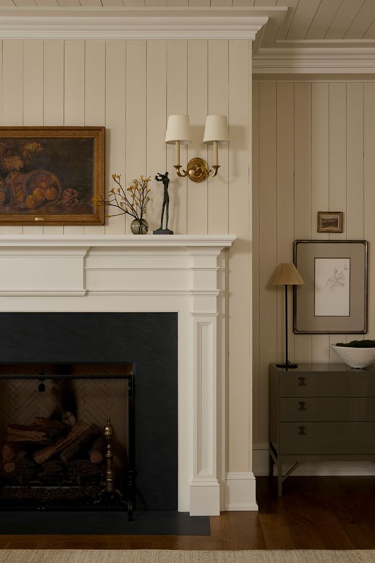 a living room with a fire place next to a painting on the fireplace mantel