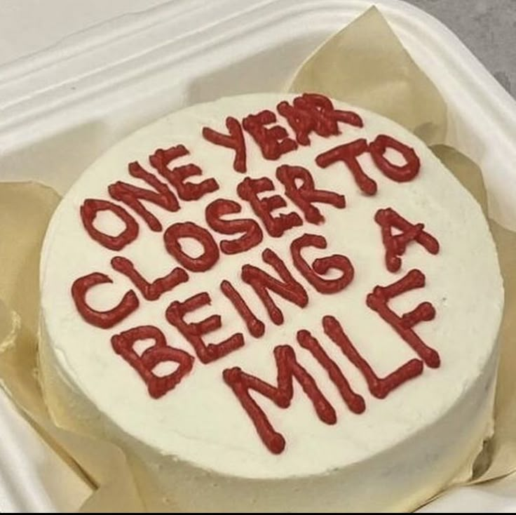 a white cake with red writing on it in a plastic container that says, one year closer to being a mile