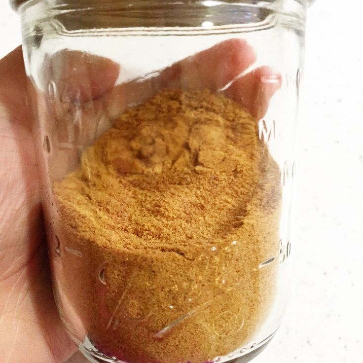 a hand holding a jar filled with sand