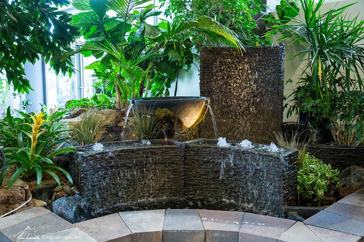 an outdoor fountain surrounded by trees and plants